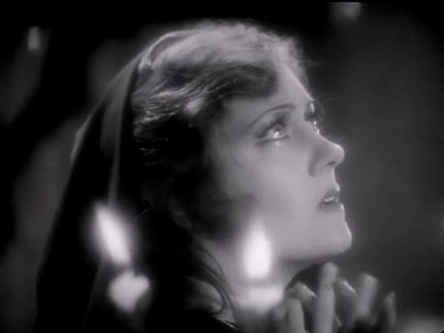 Gloria Swanson in Queen Kelly, next to two candles aflame